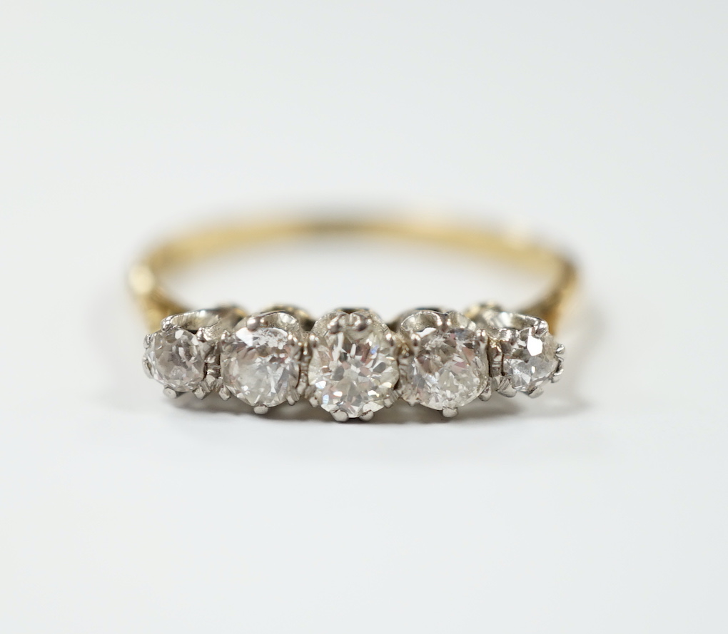 An 18ct and graduated five stone diamond set half hoop ring, size N, gross weight 2.5 grams.